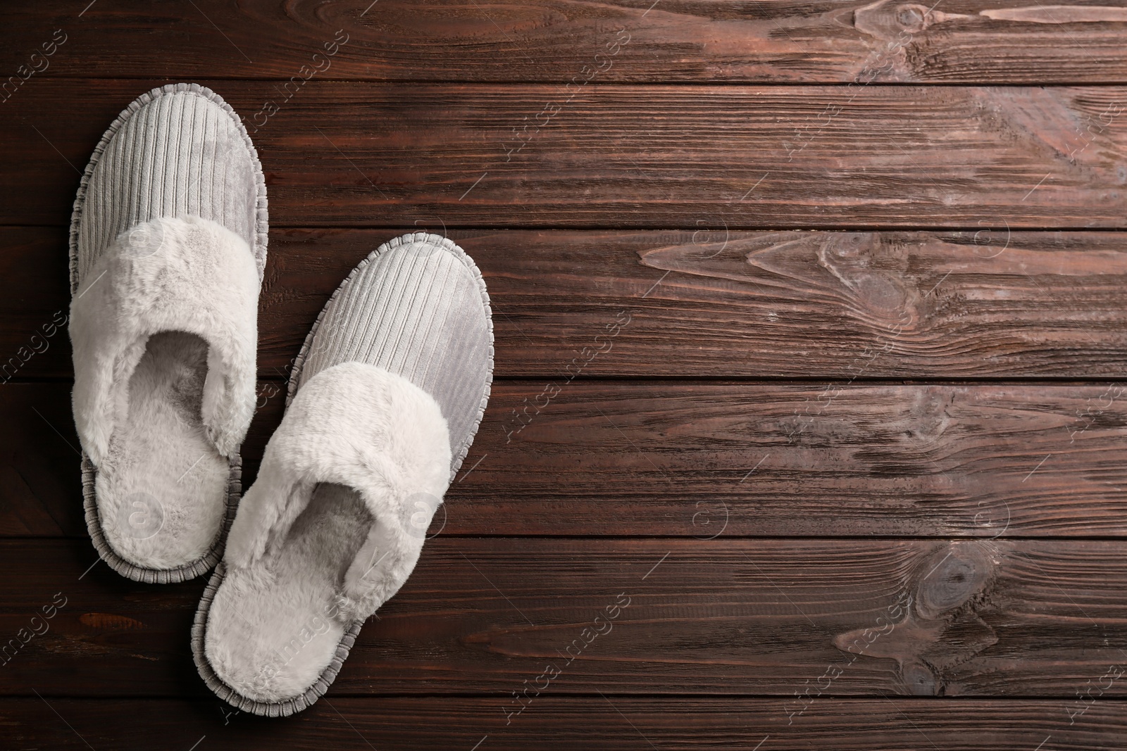 Photo of Pair of soft slippers on wooden background, flat lay. Space for text