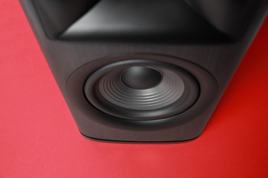 Photo of One wooden sound speaker on red background, above view