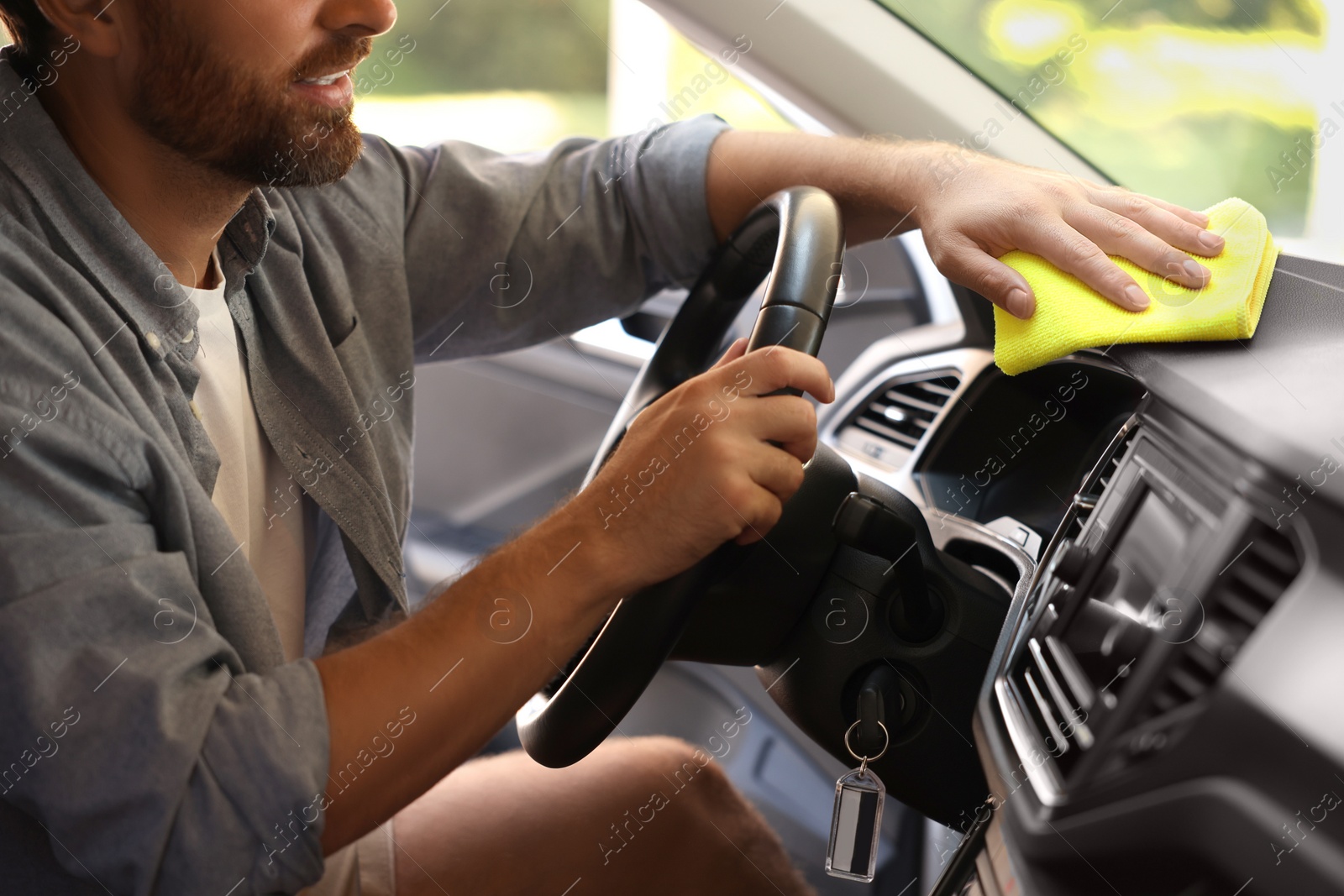 Photo of Man cleaning car interior with rag, closeup