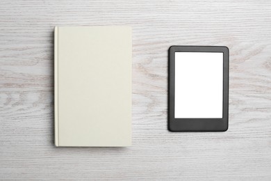 Portable e-book reader and hardcover book on white wooden table, flat lay
