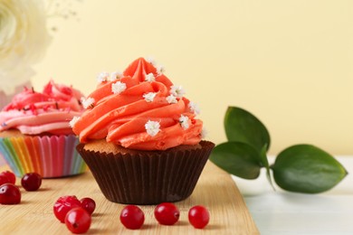 Photo of Delicious cupcake with bright cream and flowers on white table