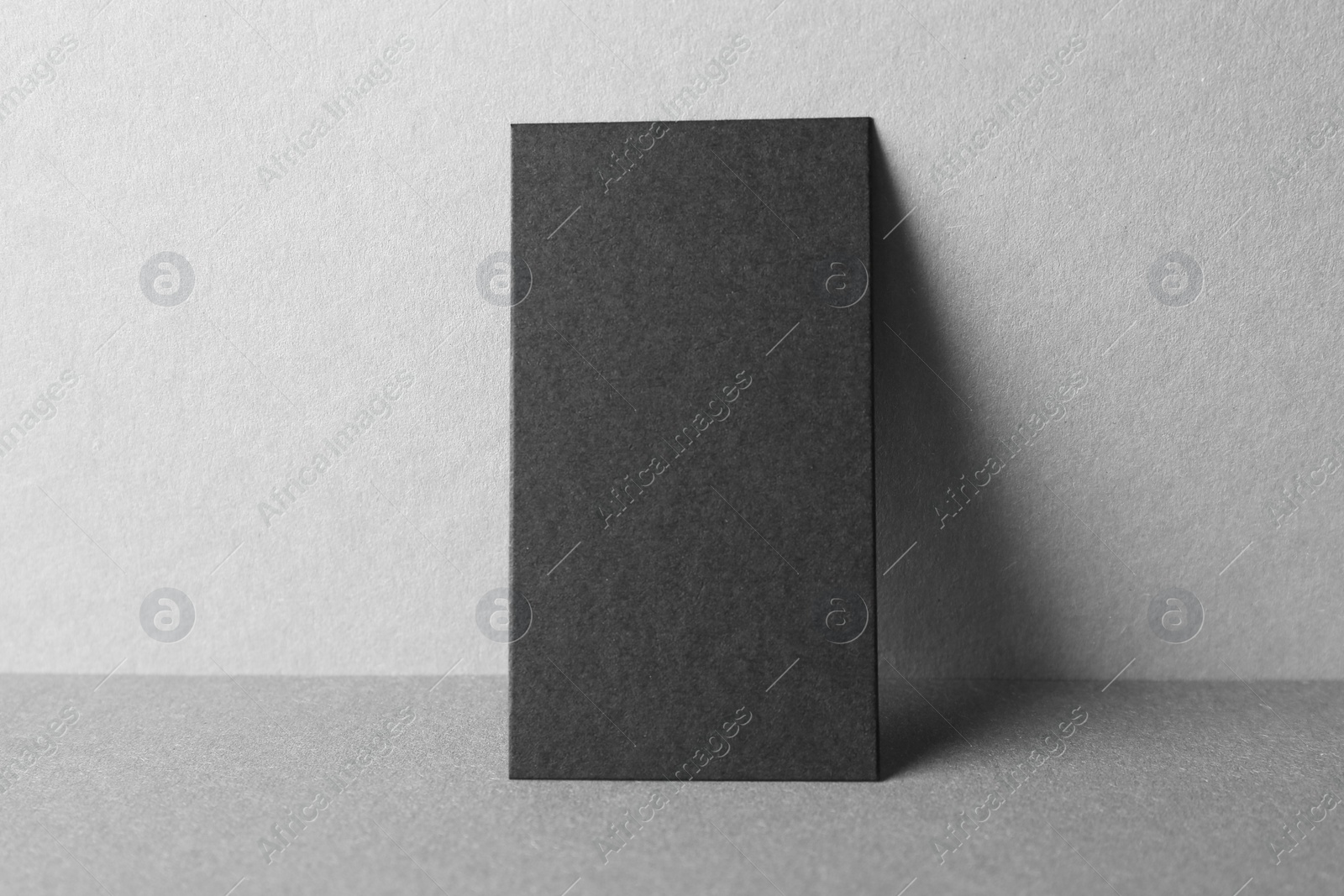 Photo of Blank black business card on grey background. Mockup for design