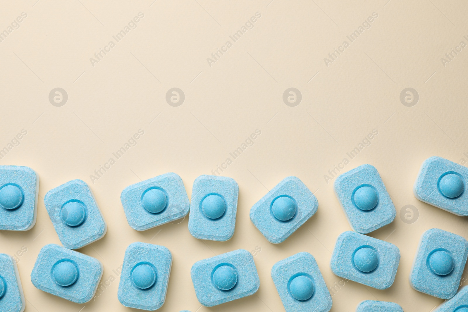 Photo of Water softener tablets on beige background, flat lay. Space for text