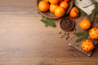 Delicious fresh tangerines and Christmas decor on wooden table, flat lay. Space for text