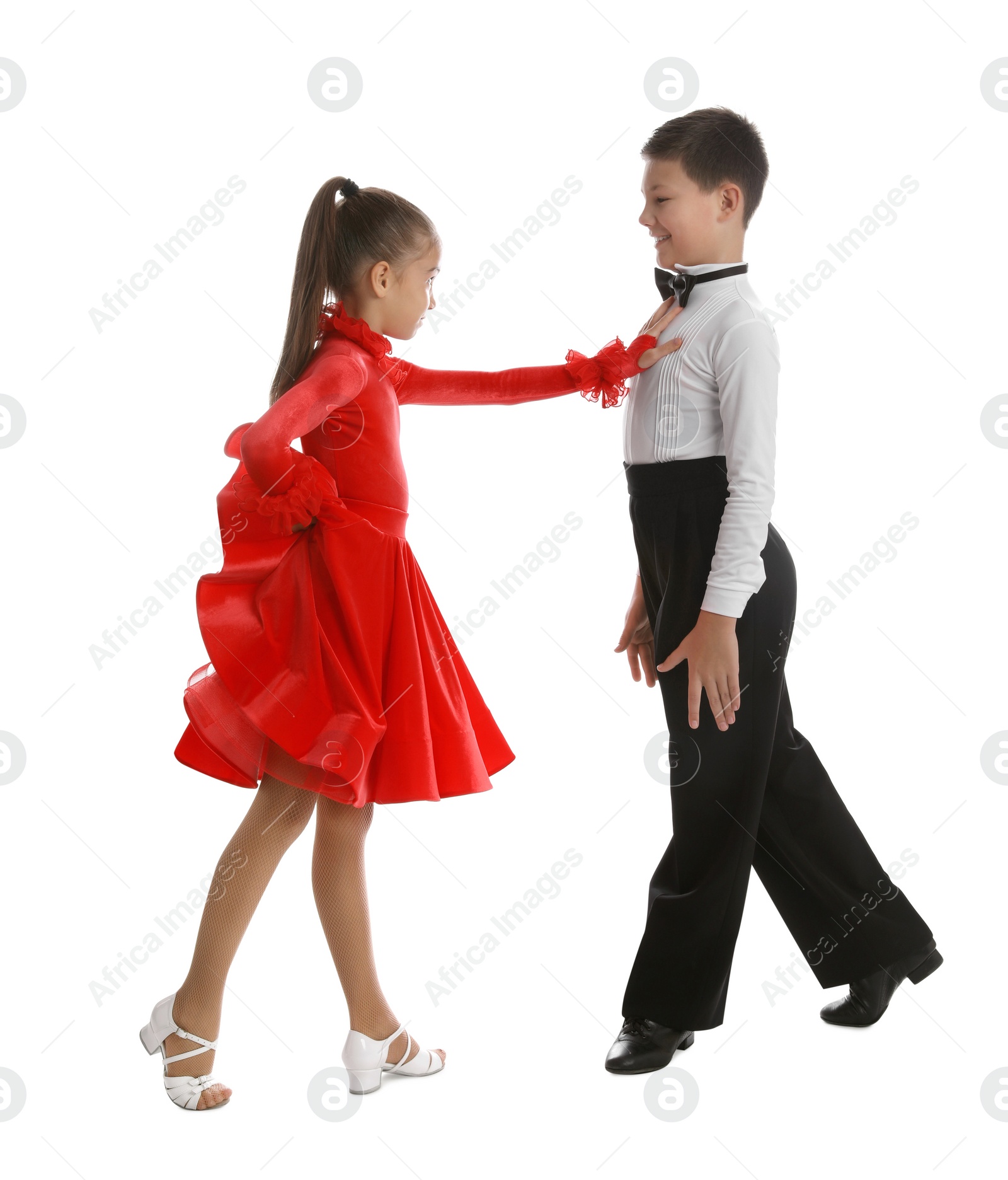 Photo of Beautifully dressed couple of kids dancing on white background