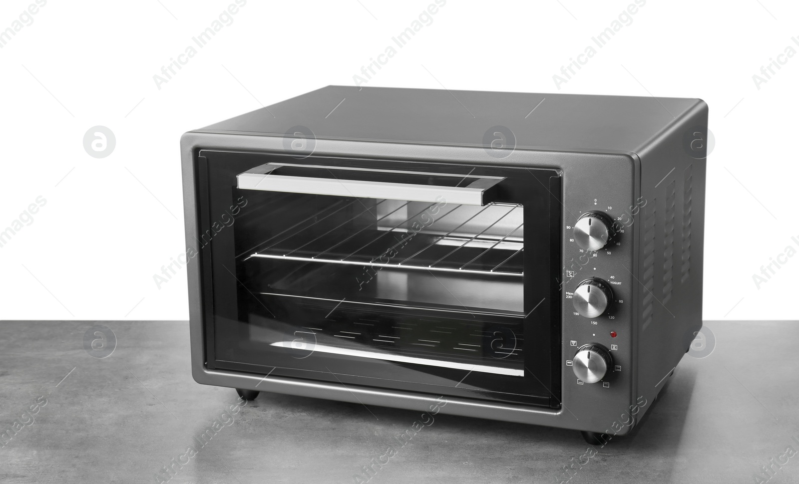 Photo of One electric oven on grey table against white background