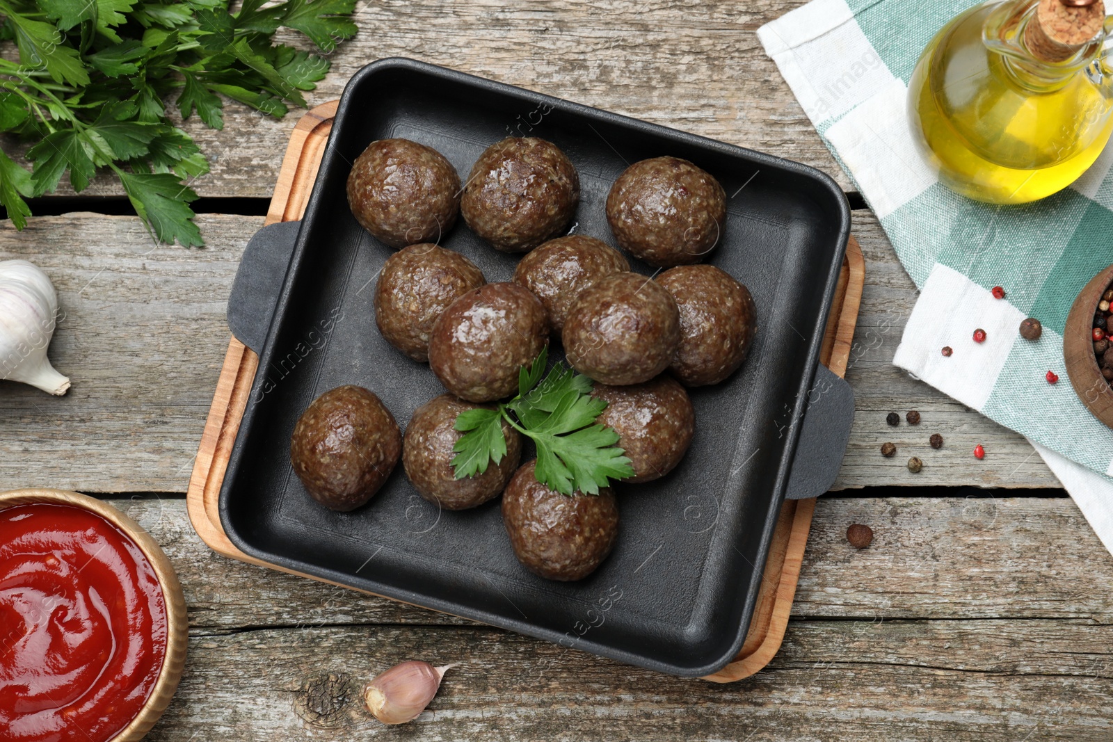 Photo of Tasty cooked meatballs with parsley on wooden table, flat lay