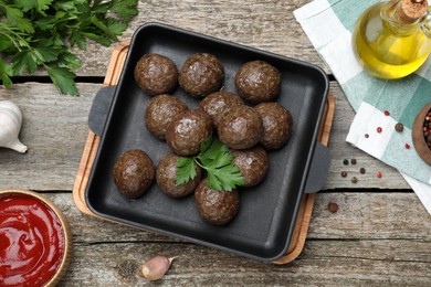 Tasty cooked meatballs with parsley on wooden table, flat lay
