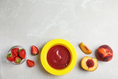 Baby food in bowl and fresh ingredients on light grey table, flat lay. Space for text