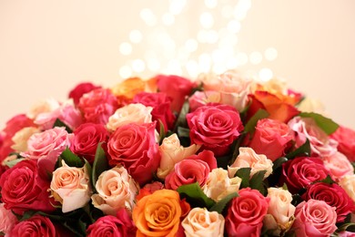 Photo of Beautiful bouquet of colorful roses on beige background, closeup