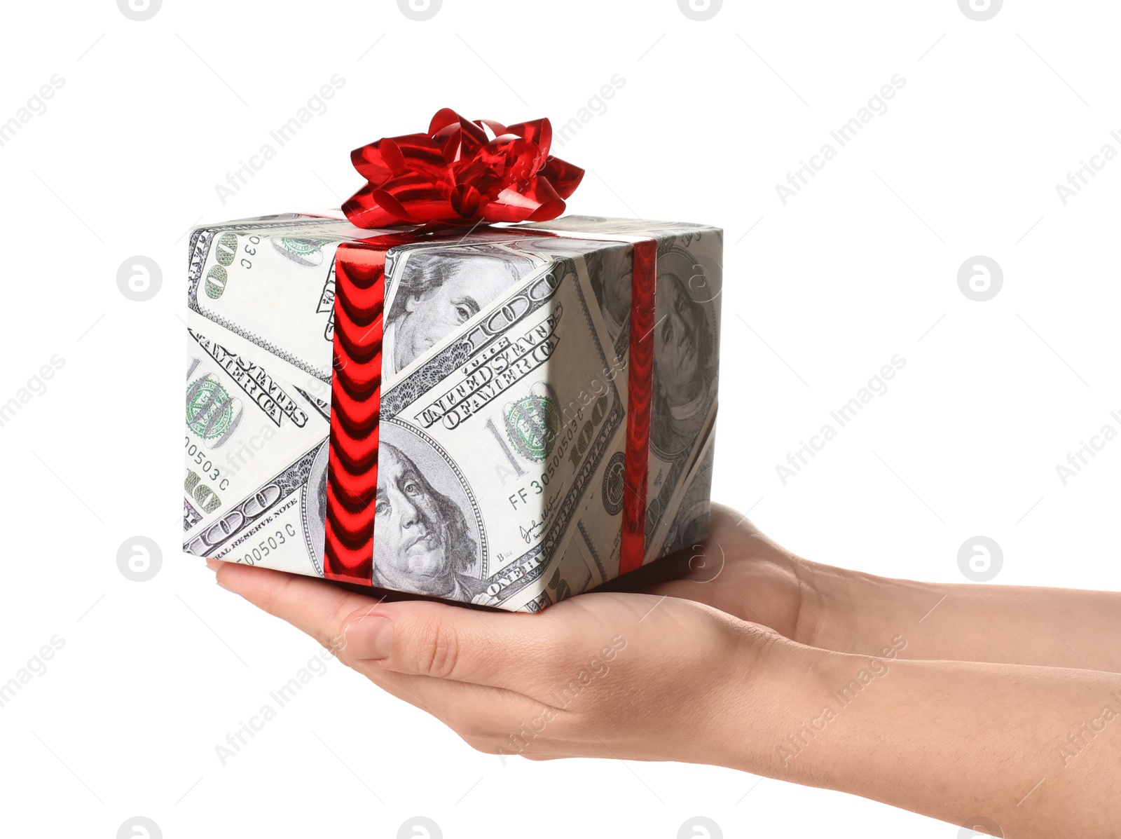 Photo of Woman holding gift box wrapped in decorative paper with dollar pattern on white background, closeup