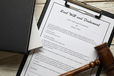 Photo of Last Will and Testament, books and gavel on white wooden table, flat lay