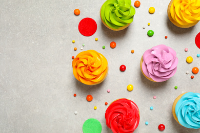 Photo of Colorful birthday cupcakes on light grey table, flat lay