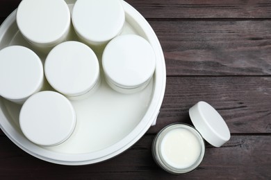 Photo of Modern yogurt maker with full jars on wooden table, flat lay