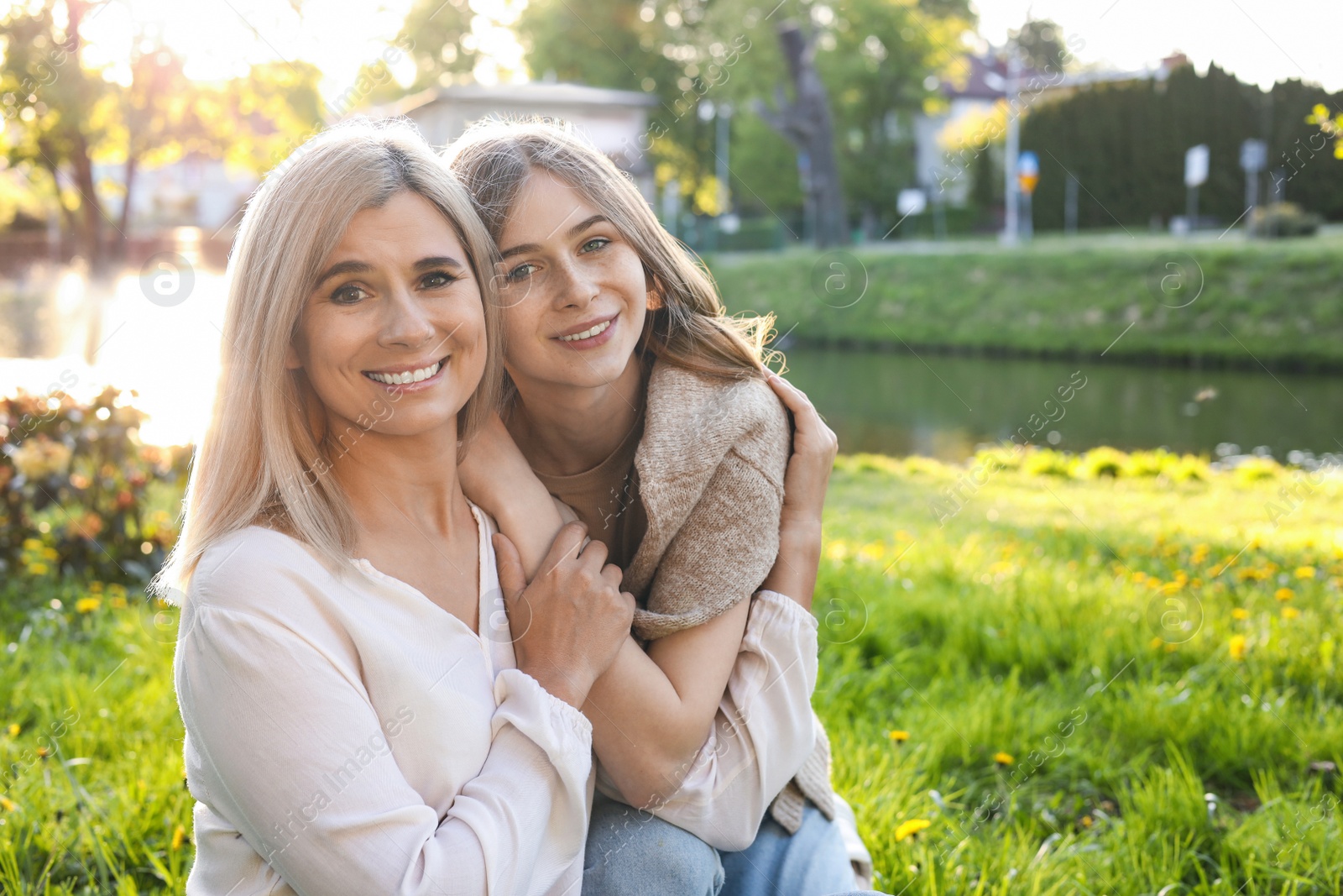 Photo of Happy mother with her daughter spending time together in park on sunny day