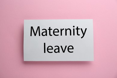 Photo of Note with text Maternity Leave on pink background, top view