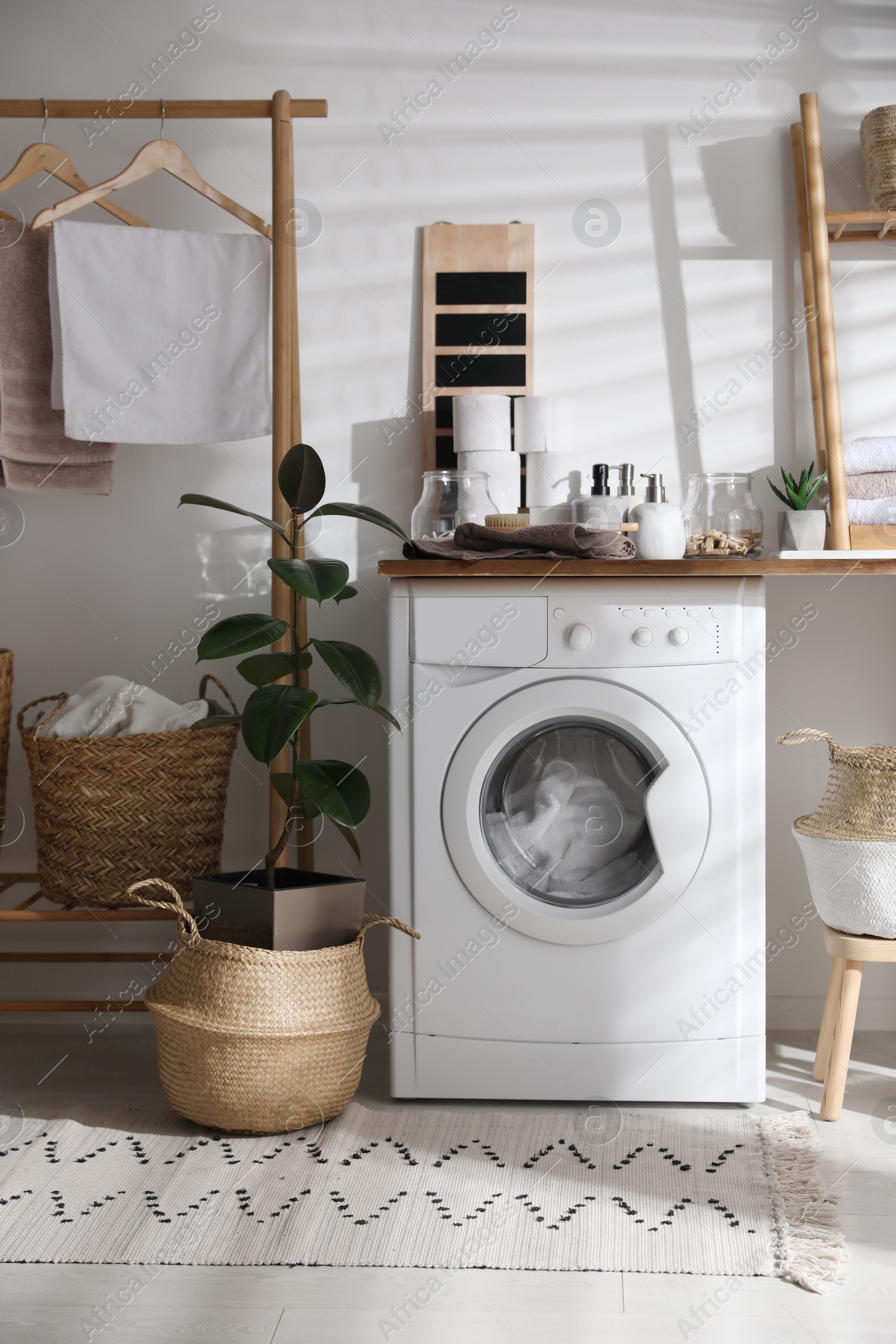 Photo of Stylish bathroom interior with modern washing machine