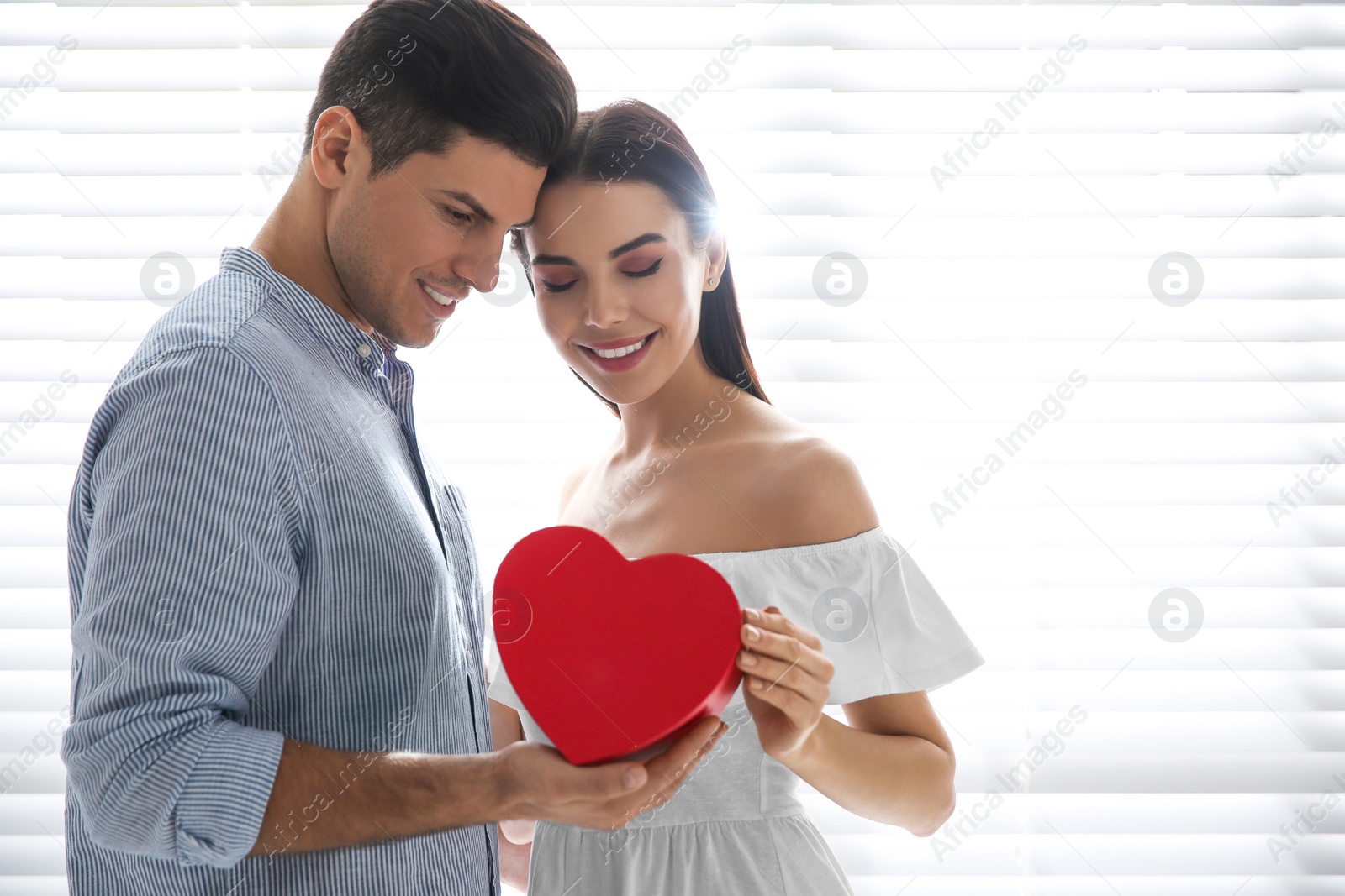 Photo of Lovely couple with gift box at home. Valentine's day celebration