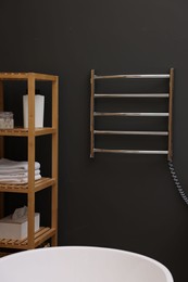 Photo of Stylish bathroom interior with heated towel rail and shelving unit