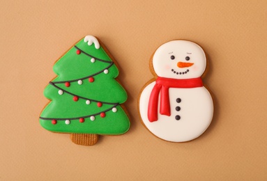 Christmas tree and snowman shaped gingerbread cookies on brown background, flat lay