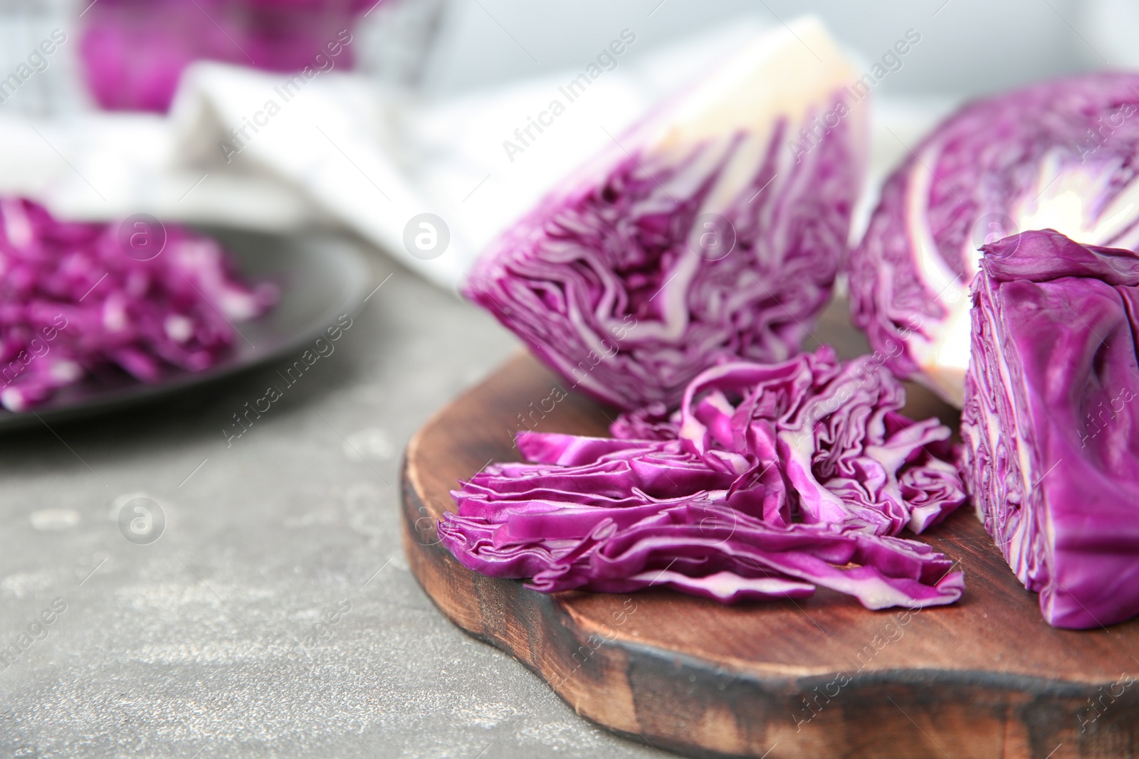 Photo of Fresh red cabbage and cutting board on kitchen table, closeup