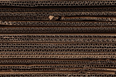 Photo of Sheets of brown corrugated cardboard as background, closeup