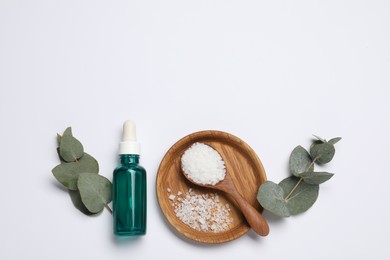 Photo of Aromatherapy products. Bottle of essential oil, sea salt and eucalyptus leaves on white background, flat lay