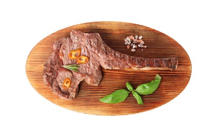 Photo of Wooden board with delicious fried beef meat, chili pepper and basil isolated on white, top view