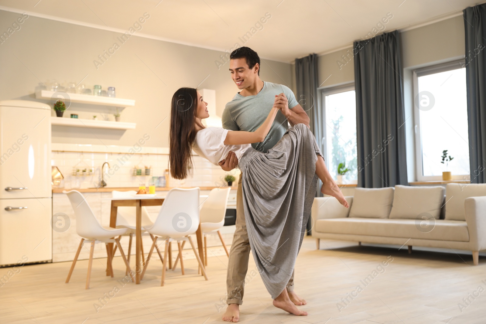 Photo of Lovely young interracial couple dancing at home