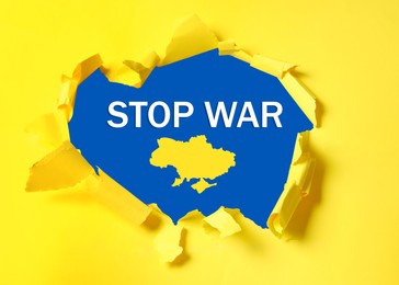 Image of Stop war in Ukraine. Outline map of Ukraine and phrase on blue background, view through torn yellow paper