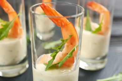 Photo of Delicious shrimp cocktail with tartar sauce served on table, closeup