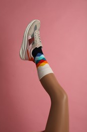 Photo of Woman wearing sneakers on pink background, closeup