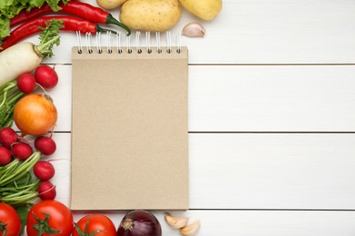 Photo of Blank recipe book and different ingredients on white wooden table, flat lay. Space for text