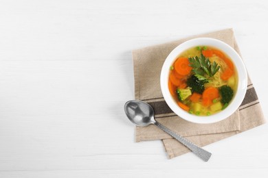 Photo of Delicious vegetable soup with noodles and spoon on white wooden table, top view. Space for text