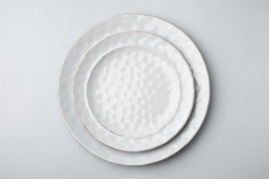 Photo of Clean plates on light grey background, top view