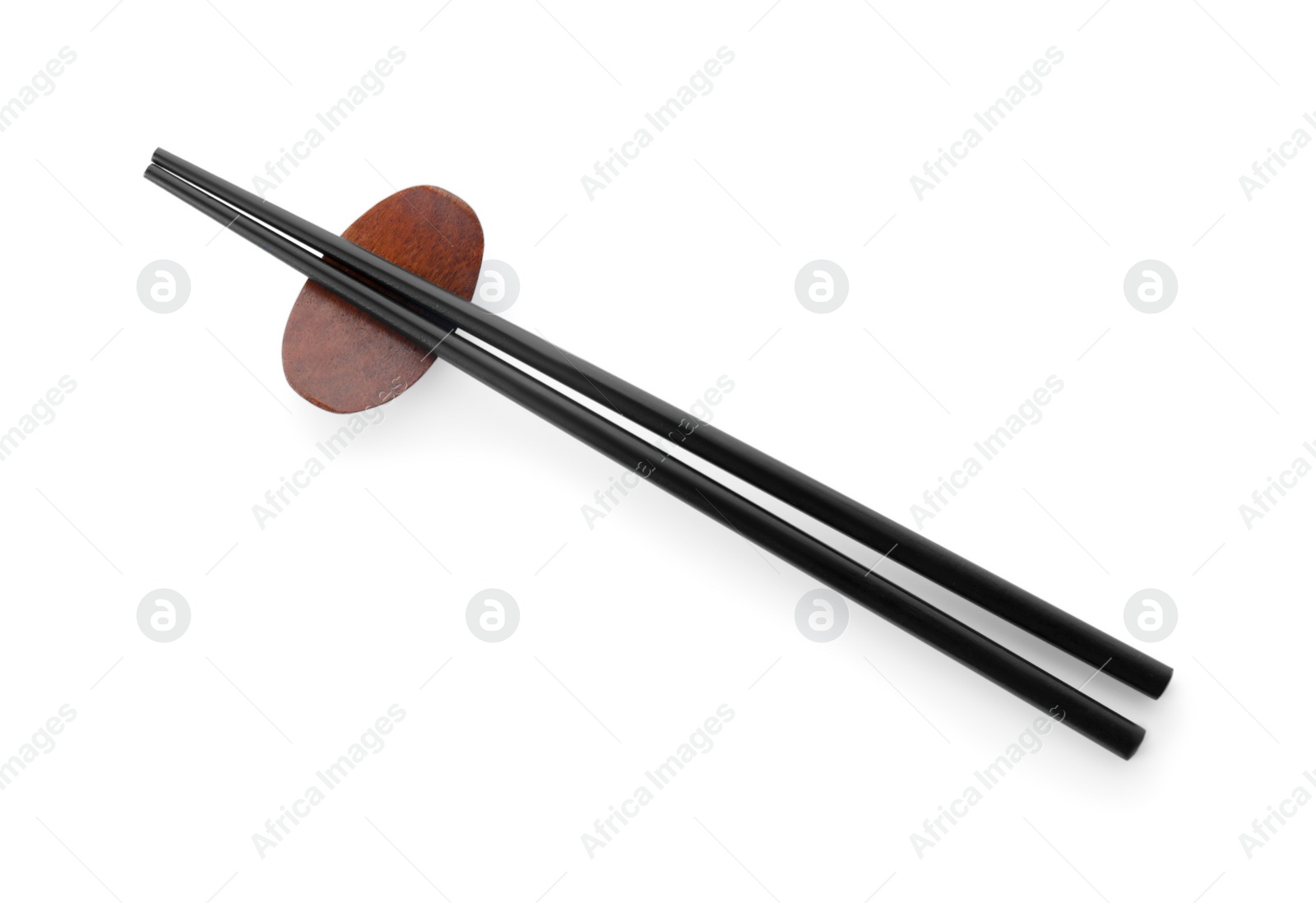 Photo of Pair of black chopsticks with rest isolated on white, top view