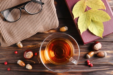 Photo of Flat lay composition with cuparomatic tea and soft sweater on wooden table. Autumn atmosphere