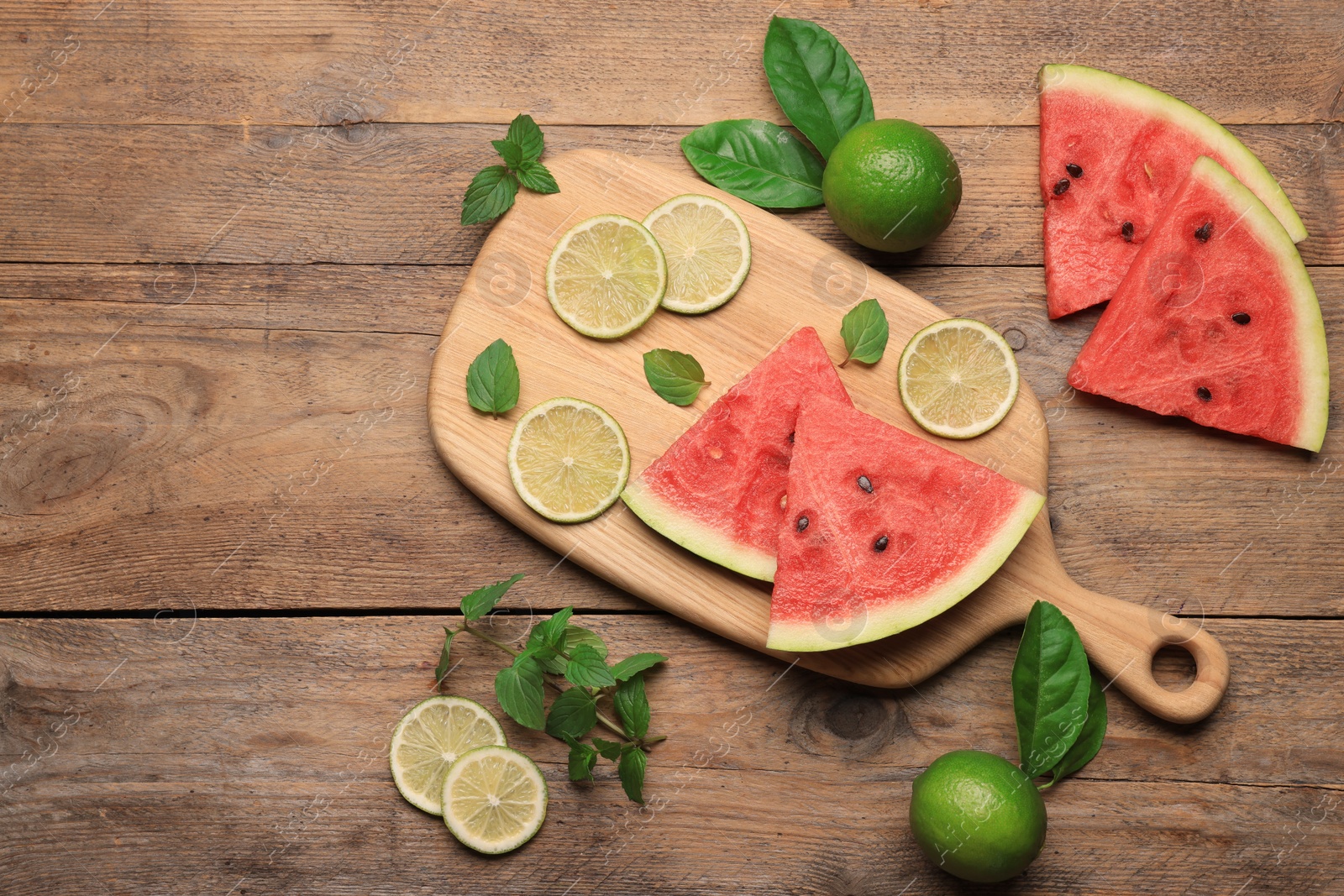 Photo of Tasty sliced watermelon and limes on wooden table, flat lay