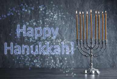 Silver menorah on grey table. Happy Hanukkah!