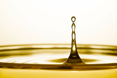 Splash of golden oily liquid on white background, closeup
