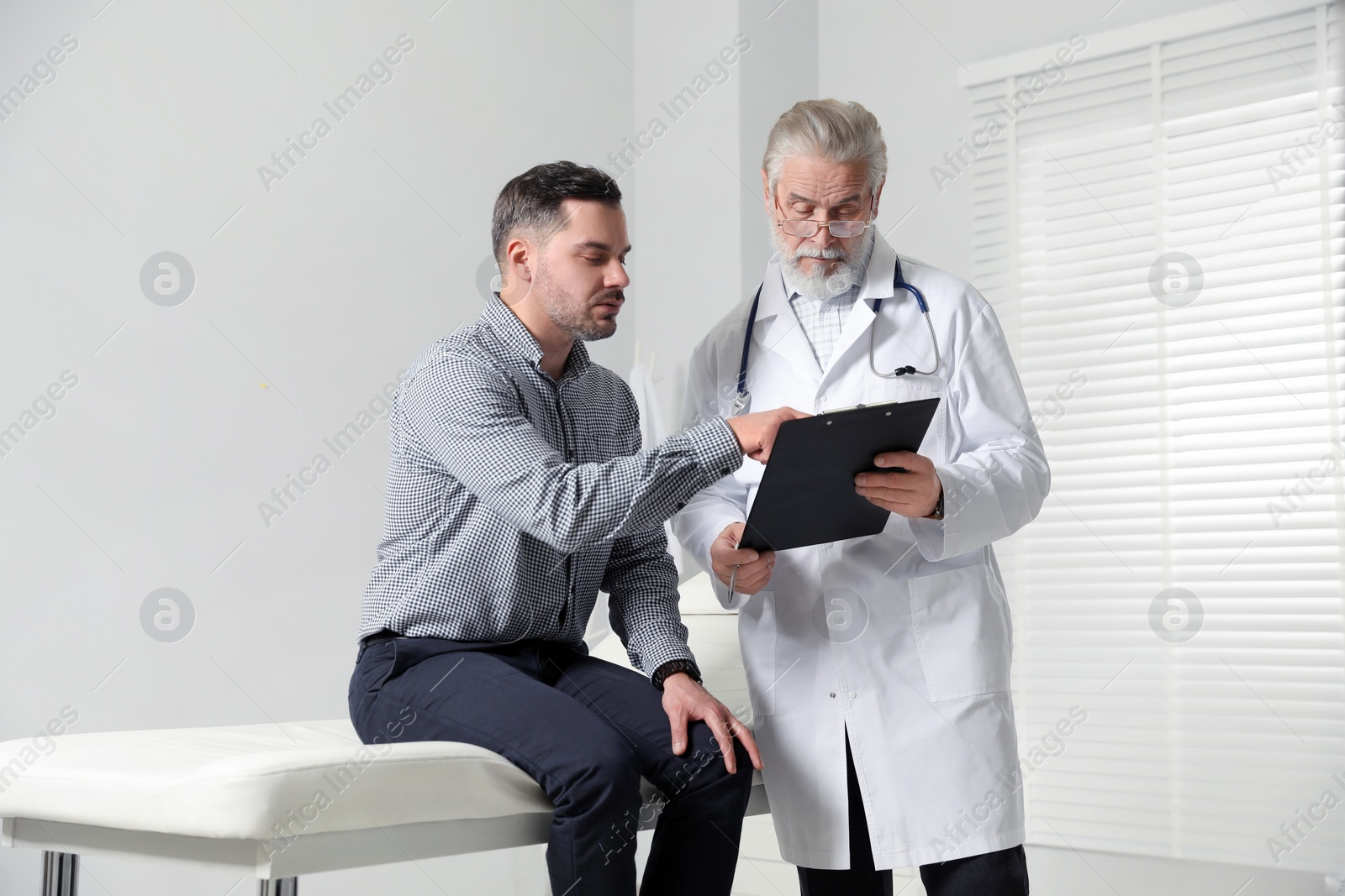 Photo of Patient having appointment with senior doctor in clinic