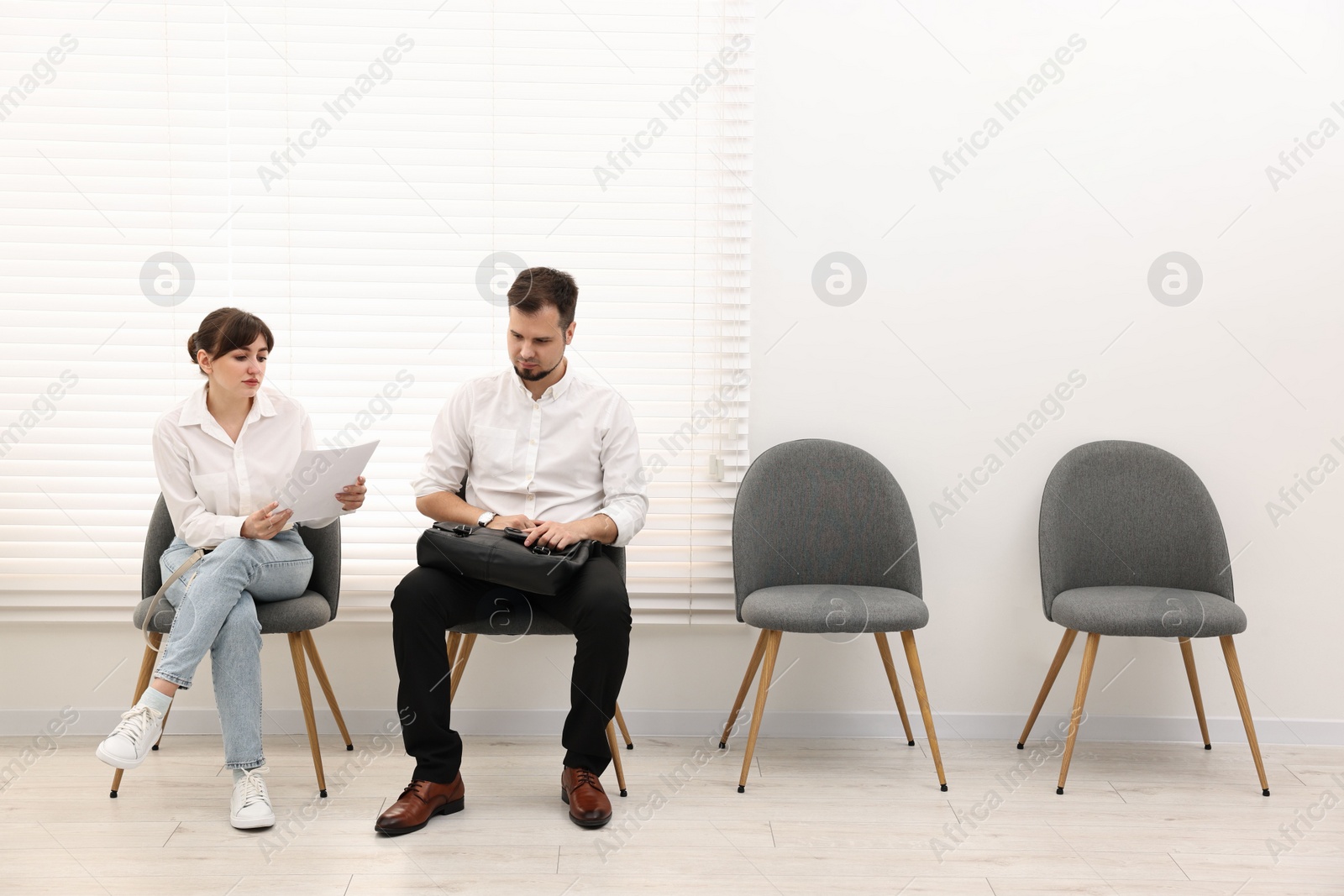 Photo of Man and woman waiting for job interview indoors