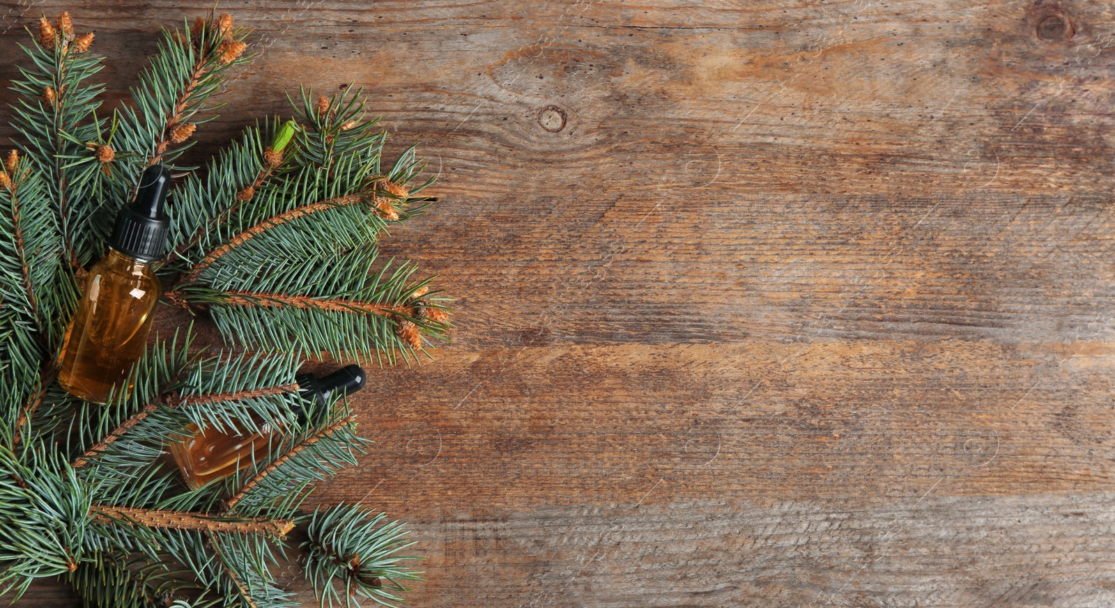 Photo of Flat lay composition with bottles of conifer essential oil and space for text on wooden background