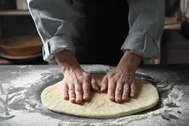 Woman making pizza dough at table, closeup