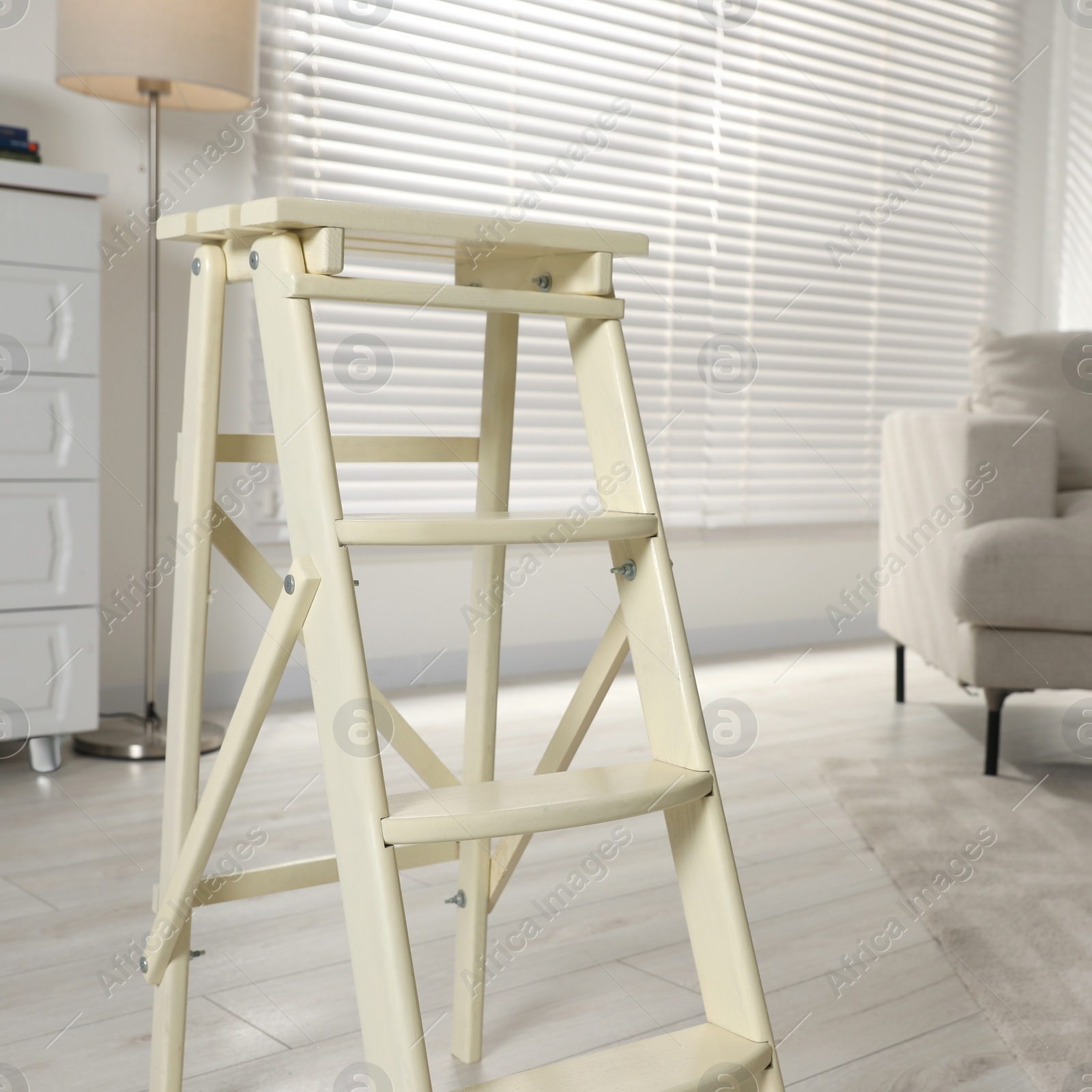 Photo of Folding ladder on wooden floor at home