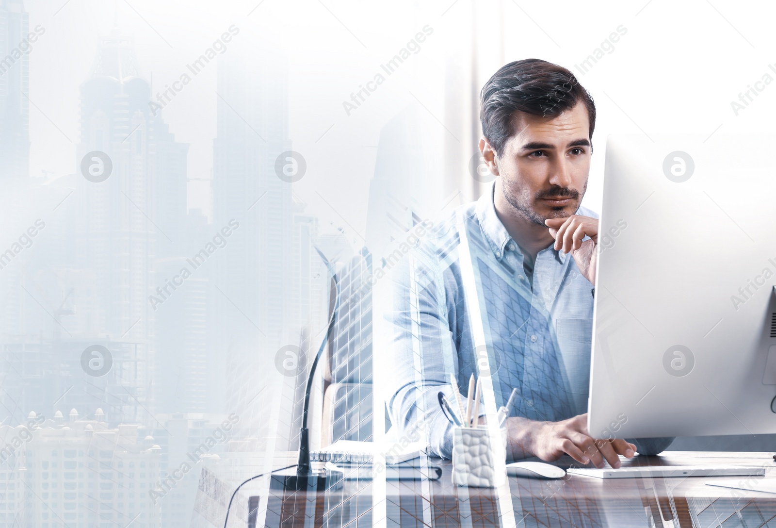 Image of Multiple exposure of architect working with computer at table and buildings