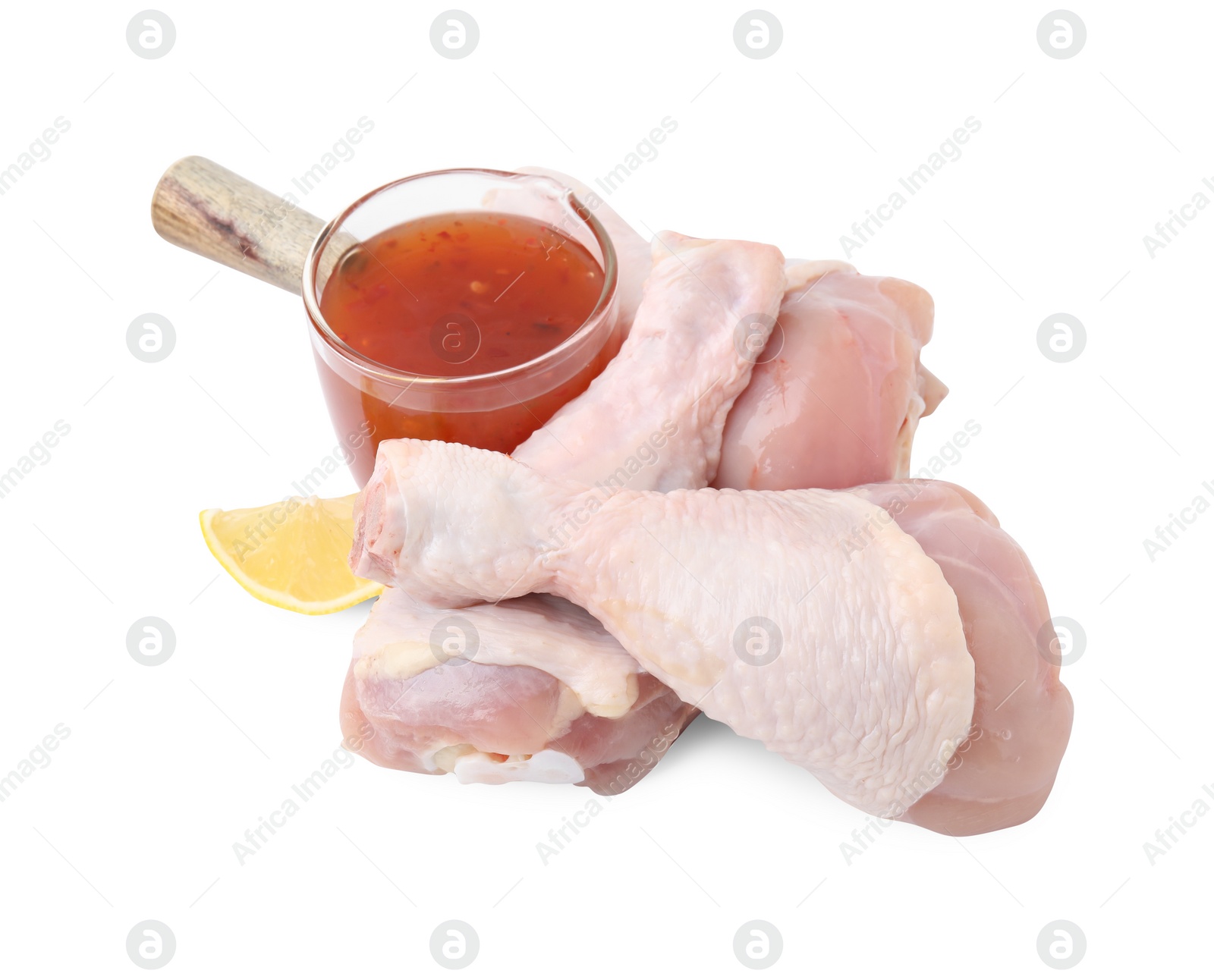 Photo of Fresh marinade, raw chicken drumsticks and lemon wedge isolated on white