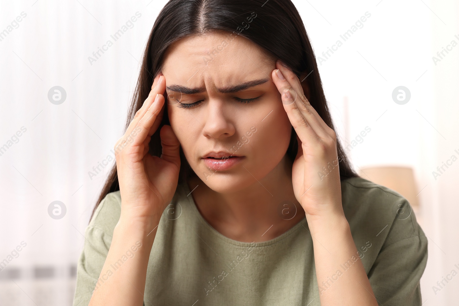 Photo of Sad woman suffering from headache at home