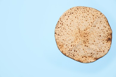 Photo of Tasty matzo on light blue background, top view with space for text. Passover (Pesach) celebration