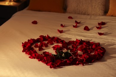 Honeymoon. Heart made with rose and beautiful petals on bed